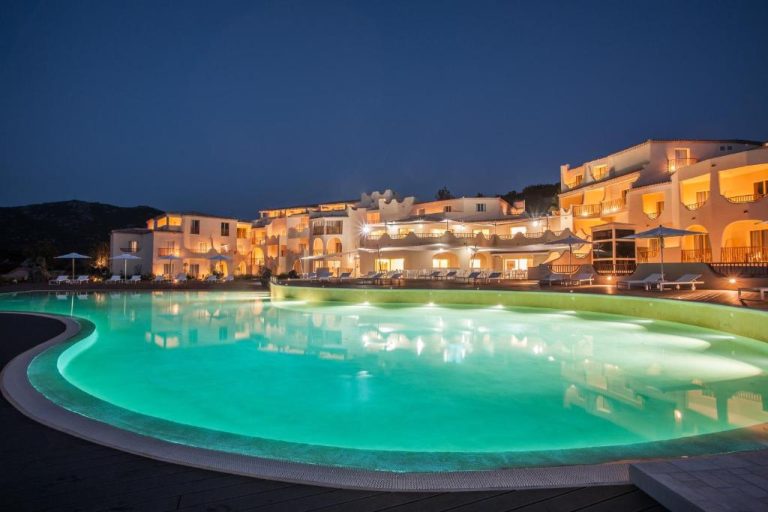 Piscina iluminada de noche con vistas al hotel Cala Cuncheddi VRetreats en Cerdeña