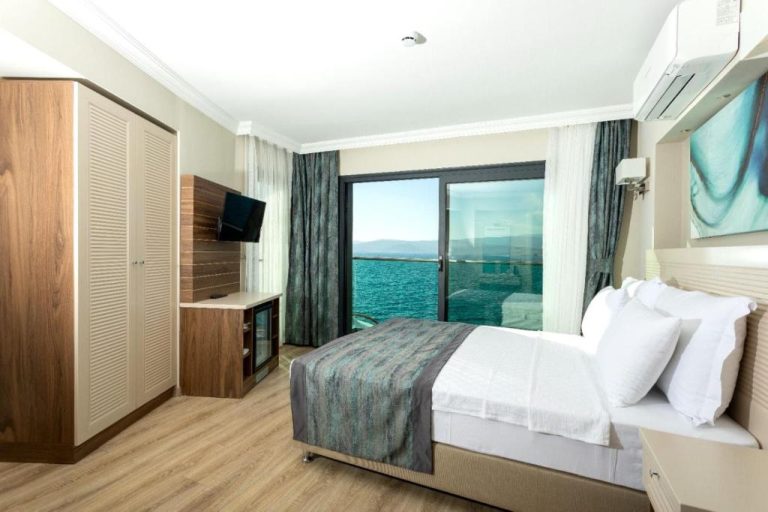 Habitación doble con cama matrimonial y vistas al mar turquesa en Güllük Yalı Boutique Otel