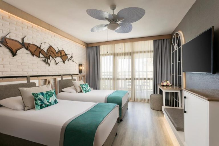 Habitación doble con dos camas y decoración tropical en Limak Arcadia Sport Resort Belek