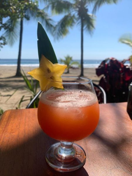 Cóctel tropical con carambola y vista a la playa en Beach Front Bahia Hotel
