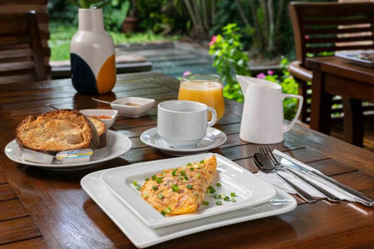 Desayuno con tortilla francesa y zumo de naranja en la terraza del Hotel Villa Colonial