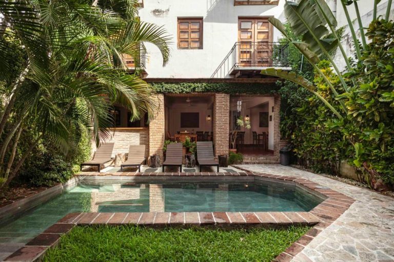 Piscina privada con jardín tropical y tumbonas del Hotel Villa Colonial