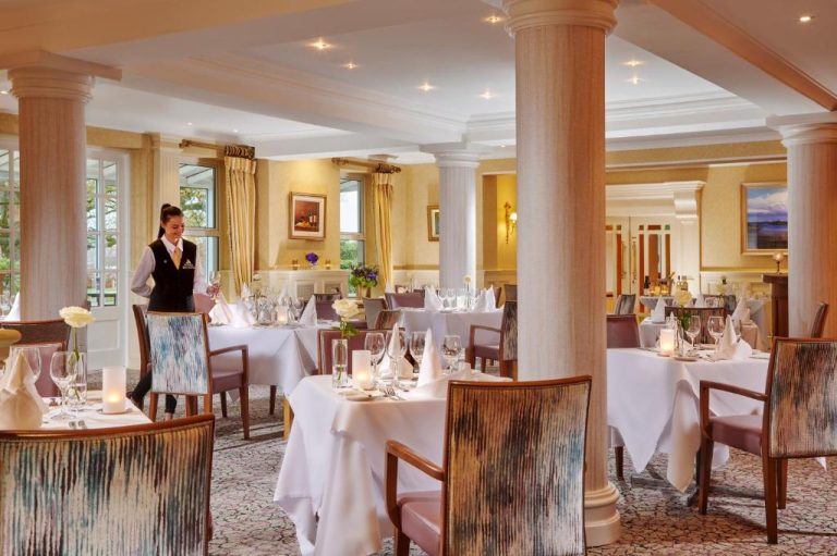 Elegante restaurante del Hodson Bay Hotel con mesas vestidas de blanco y servicio de lujo