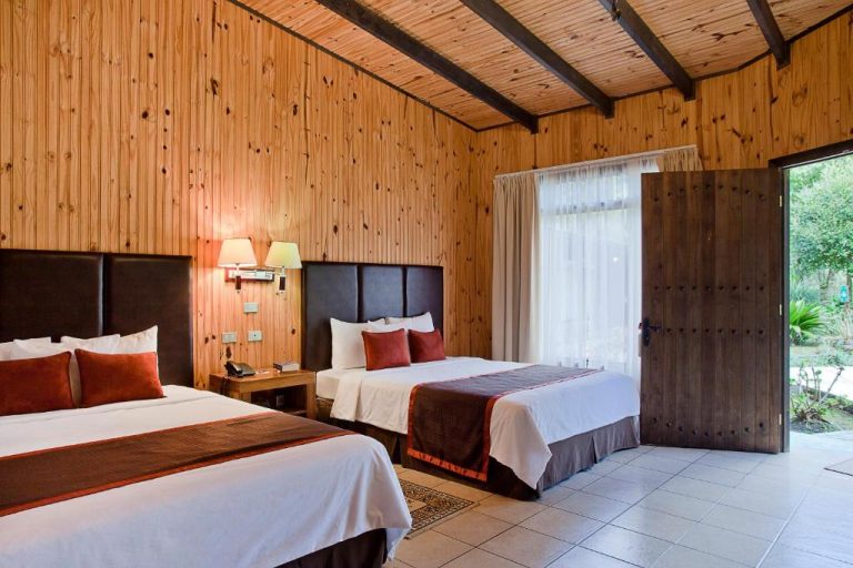 Habitación doble con paredes de madera y dos camas en Savegre Hotel Natural Reserve & Spa