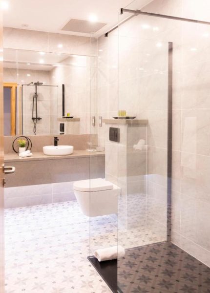 Baño moderno con ducha de cristal y sanitario suspendido en Wineport Lodge