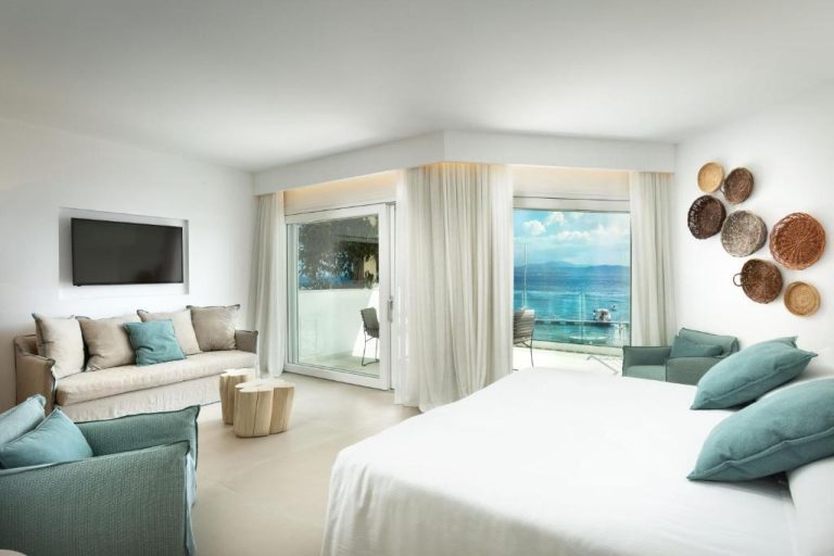 Suite de lujo con cama doble, sofá y terraza con vistas al mar en Gabbiano Azzurro Hotel & Suites