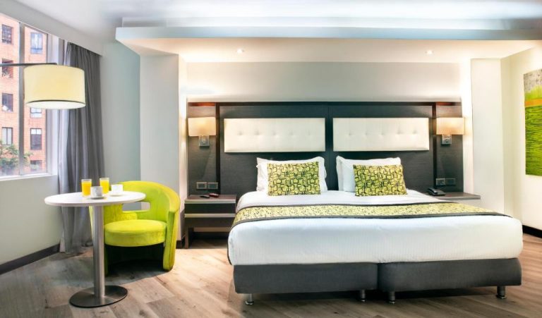 Habitación doble moderna con cama king size y decoración en verde lima en Hotel City Bog Expo Museo Bogotá