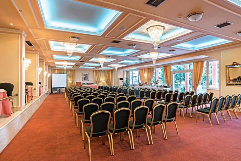Amplio salón de conferencias con sillas y pantalla de proyección en el Hotel Philippos Livadeia