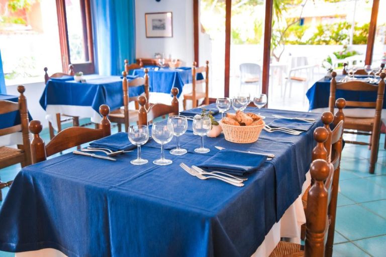 Comedor del Hotel Europa con mesas preparadas con manteles azules, copas de vino y cesta de pan