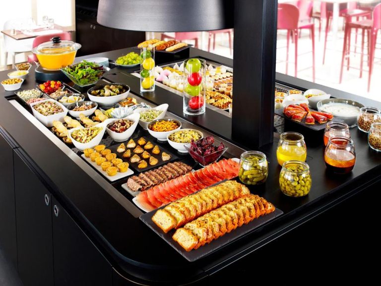 Amplio buffet de desayuno con pan, frutas, ensaladas y conservas en el Hotel Campanile Montluçon Saint-Victor