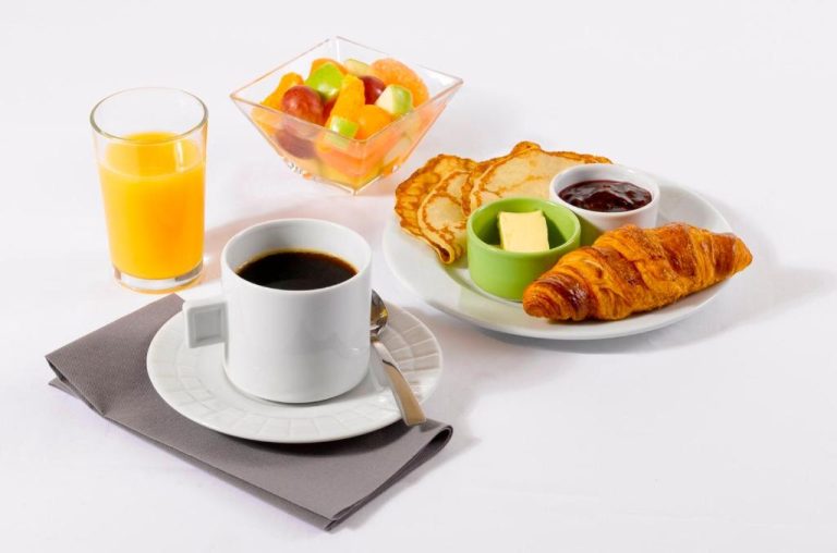 Desayuno continental del Hotel Campanile Montluçon con cruasán, tortitas, zumo de naranja y ensalada de frutas