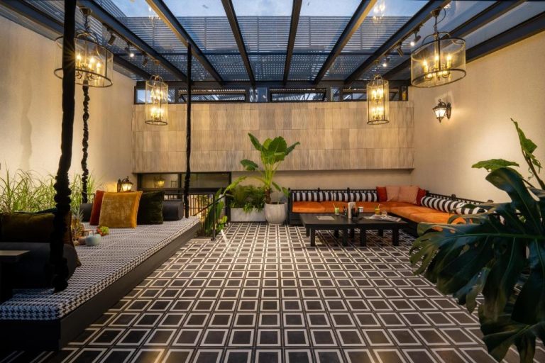 Elegante terraza lounge con sofás naranjas y lámparas colgantes en Sanouva Da Nang Hotel