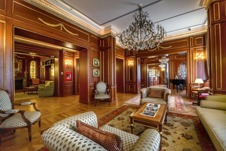 Elegante salón clásico con paneles de madera y araña de cristal del Grand Hotel Wagner