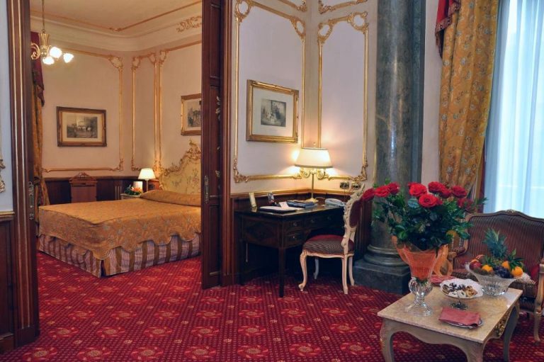 Suite clásica con escritorio antiguo, columna mármol y decoración dorada del Grand Hotel Wagner