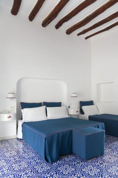 Habitación doble con suelo hidráulico azul y cama con ropa de cama azul en Hotel La Terrazza