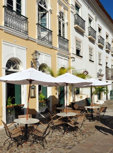 Terraza exterior con mesas y sombrillas blancas del Hotel Villa Bahia en Salvador de Bahía