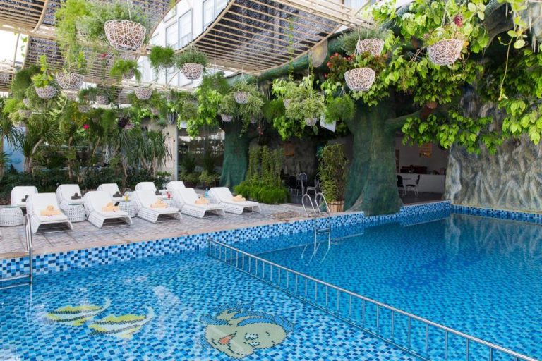 Piscina interior con decoración tropical y tumbonas del Galina Hotel & Spa