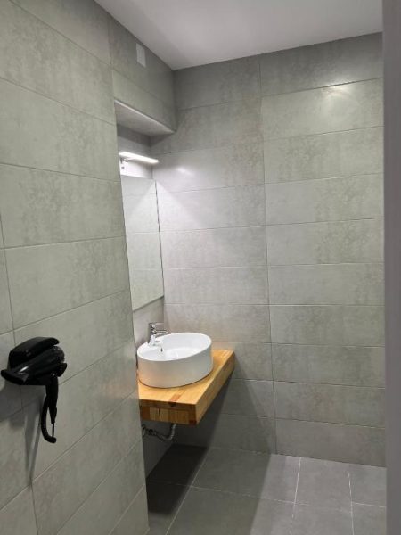 Baño moderno con lavabo de diseño sobre encimera de madera en Kimiro Hotel Tsilivi