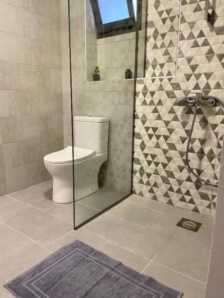 Baño moderno con ducha abierta y decoración geométrica en el Kimiro Hotel Tsilivi