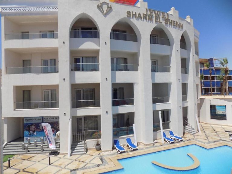Fachada blanca con arcos y piscina exterior del Jewel Sharm El Sheikh Hotel en Egipto