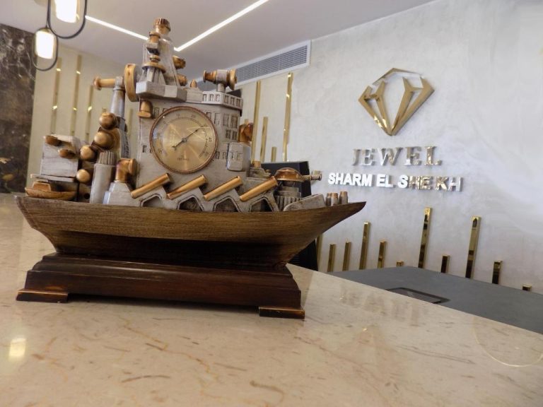 Recepción del Jewel Sharm El Sheikh Hotel con escultura decorativa de barco y reloj en mármol