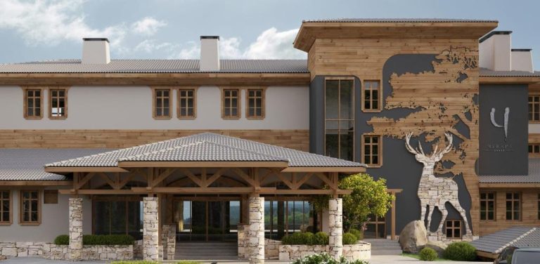Fachada exterior del Wine & SPA Hotel Chukara con decoración de madera y escultura de ciervo en relieve