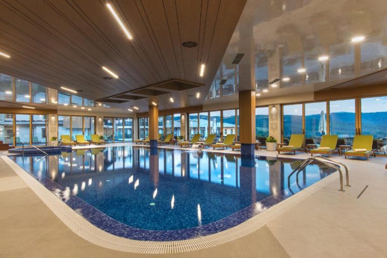 Piscina interior climatizada con tumbonas y vistas panorámicas a la montaña en Wine & SPA Hotel Chukara
