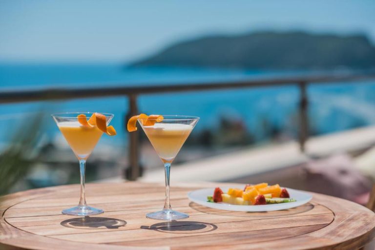 Cócteles de naranja en terraza con vistas al mar y plato de frutas frescas en Iberostar Waves Slavija