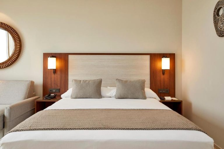Habitación doble con cama matrimonial y cabecero de madera en el Hotel Riu Jambo All Inclusive
