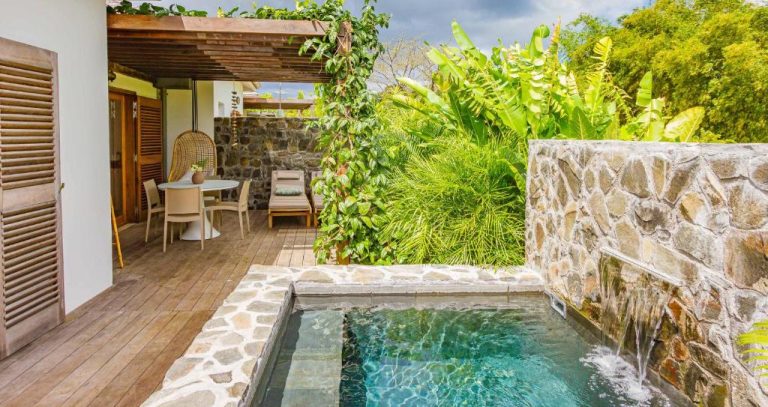 Piscina privada con cascada y terraza de madera en Habitation Saint Charles Hôtel de Charme & Spa