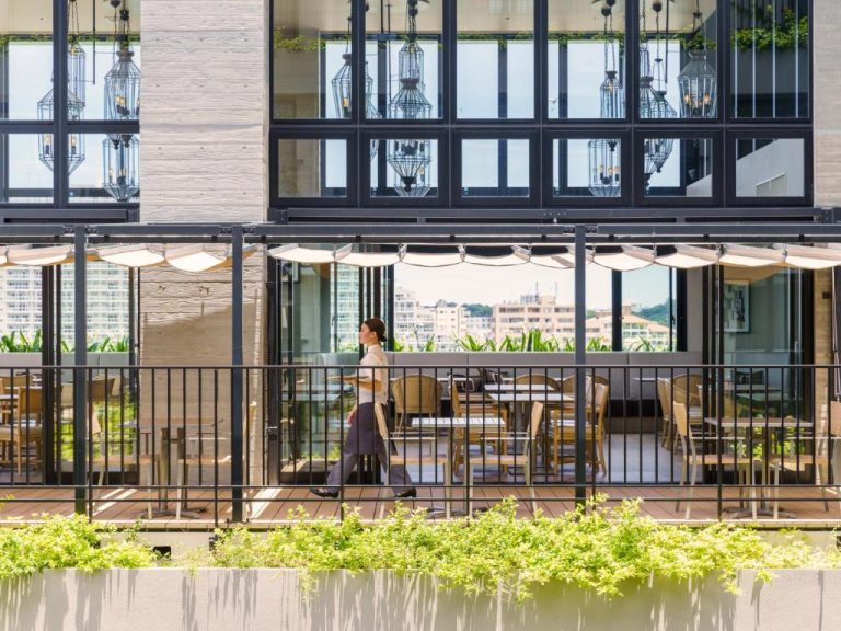 Terraza exterior con mesas y sombrillas del MB Gallery Chatan by The Terrace Hotels en Okinawa