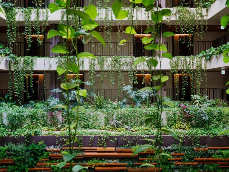 Jardín interior vertical con plantas tropicales colgantes en MB Gallery Chatan by The Terrace Hotels