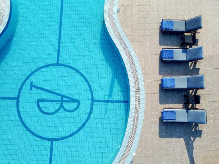 Vista aérea de la piscina exterior con tumbonas azules del Alykanas Beach Grand Hotel by Zante Plaza