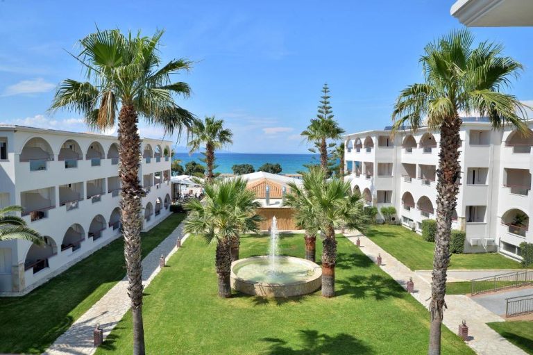 Jardín con fuente central y palmeras del Alykanas Beach Grand Hotel by Zante Plaza con vistas al mar