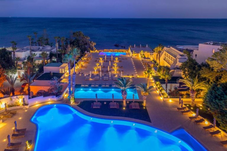 Vista aérea nocturna de las piscinas iluminadas del Royal Azur Thalassa con vistas al mar