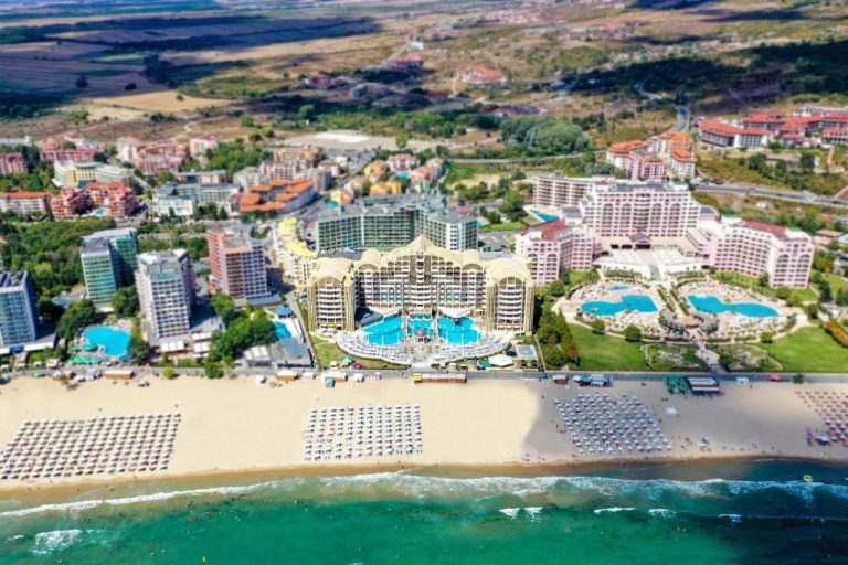 Vista aérea del Imperial Palace Hotel con piscinas exteriores y playa de arena en la costa búlgara
