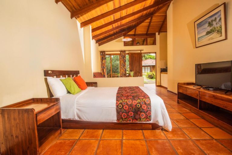 Habitación doble con techo de madera y suelo de terracota en Nandel Beach Resort
