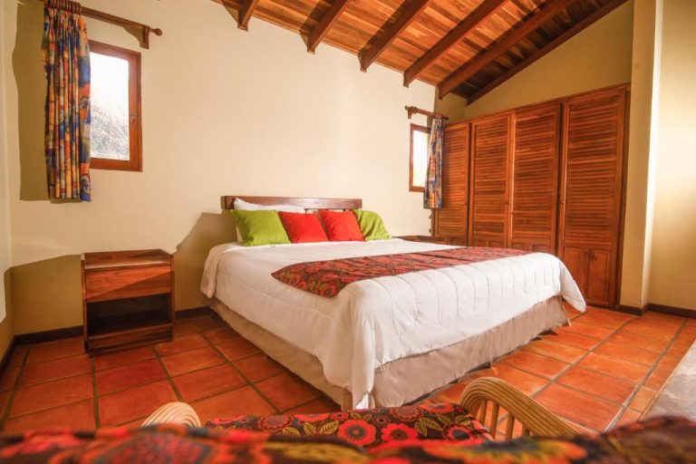 Habitación doble con techo de madera y cama matrimonial en Nandel Beach Resort