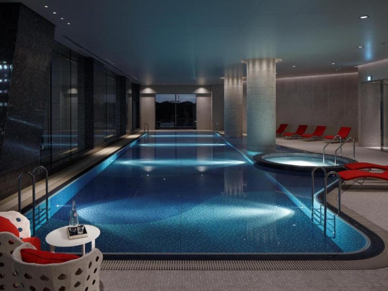 Piscina interior climatizada con jacuzzi y tumbonas rojas del Palace Hotel Tokyo
