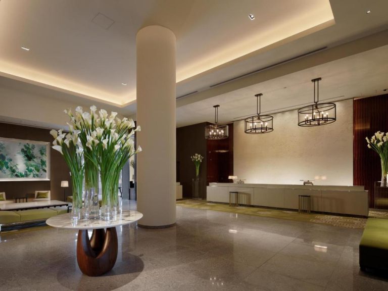 Lujoso lobby del Palace Hotel Tokyo con flores blancas y elegante recepción iluminada