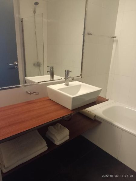 Baño completo con bañera, lavabo sobre encimera de madera y ducha en Buenos Aires Apartamento