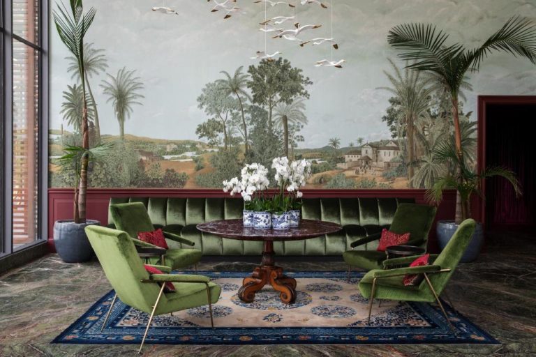 Elegante salón del Hotel Montevideo con sillones de terciopelo verde y mural tropical pintado en la pared