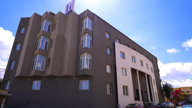 Fachada exterior del Aitch Boutique Hotel con arquitectura moderna y cielo azul