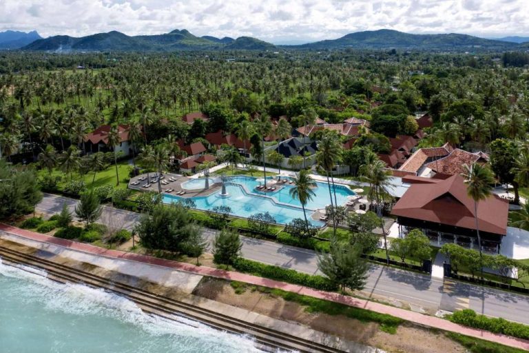 Vista aérea de la piscina exterior y villas del Wyndham Hua Hin Pranburi Resort rodeado de palmeras