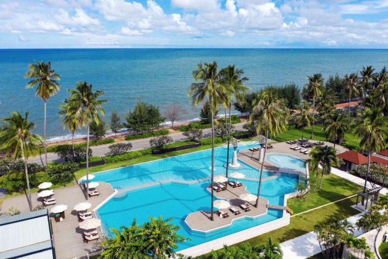 Piscina exterior con palmeras y vistas al mar del Wyndham Hua Hin Pranburi Resort & Villas