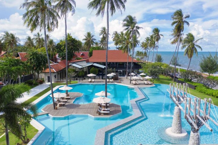 Piscina exterior con sombrillas y vistas al mar del Wyndham Hua Hin Pranburi Resort & Villas