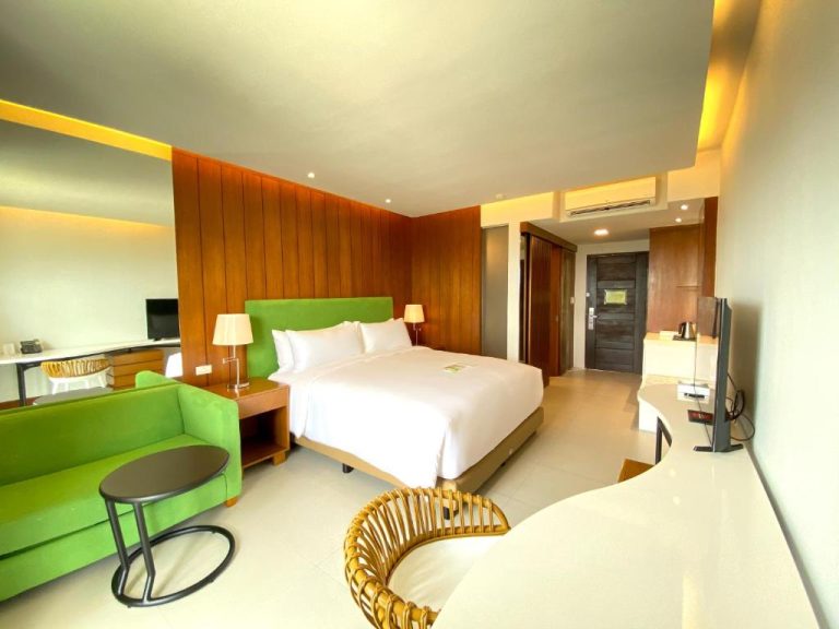 Habitación deluxe con cama doble y sofá verde en Timberland Highlands Resort