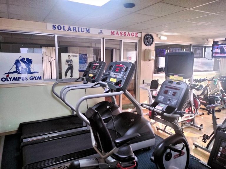 Gimnasio completo con cintas de correr y bicicletas estáticas en el Almond Business Hotel
