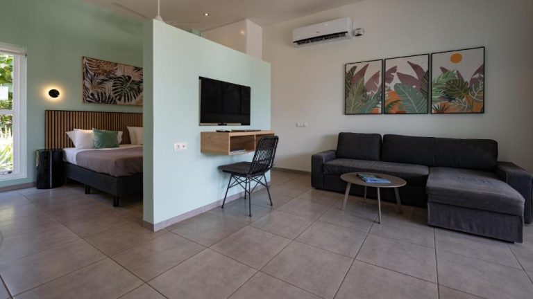 Suite con salón y dormitorio integrado en Blue Bay Lodges, decoración tropical moderna