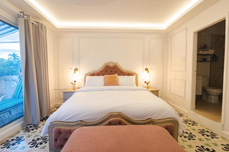 Habitación doble de lujo con cama king size y cabecero tapizado en rosa en Casa Hadasa